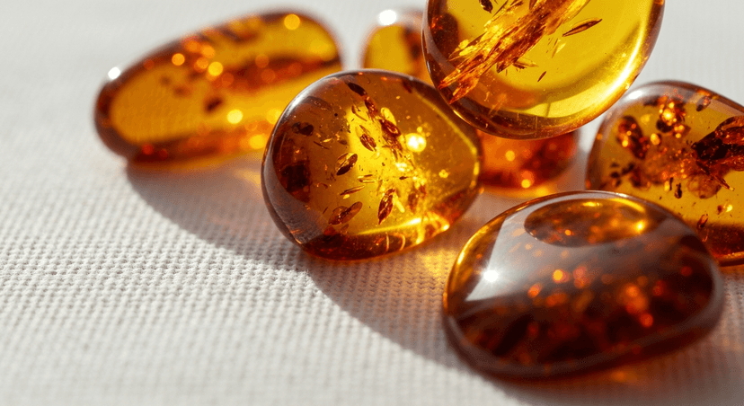 Polished amber stones in honey and cognac colors with light shining through